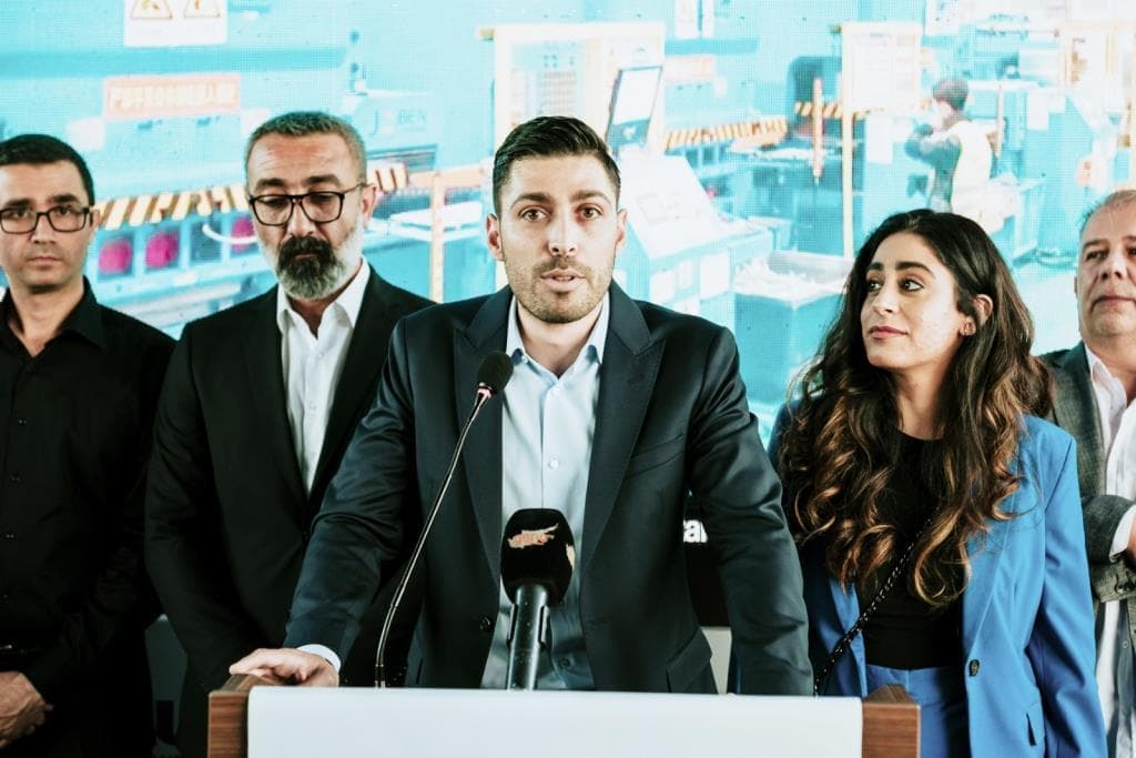 AUX klima lansmanında kürsüde konuşan bir yönetici ve arkasında şirket temsilcileri